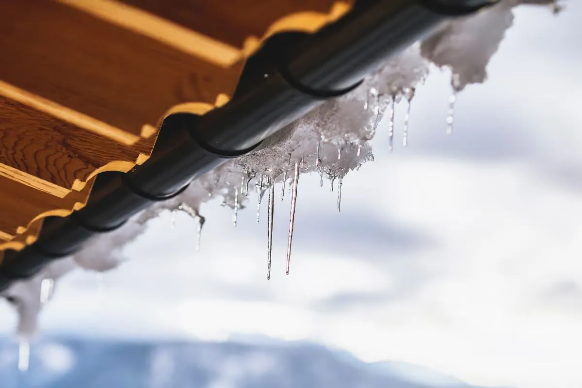 Eiszapfen an der Dachkante eines Chalets