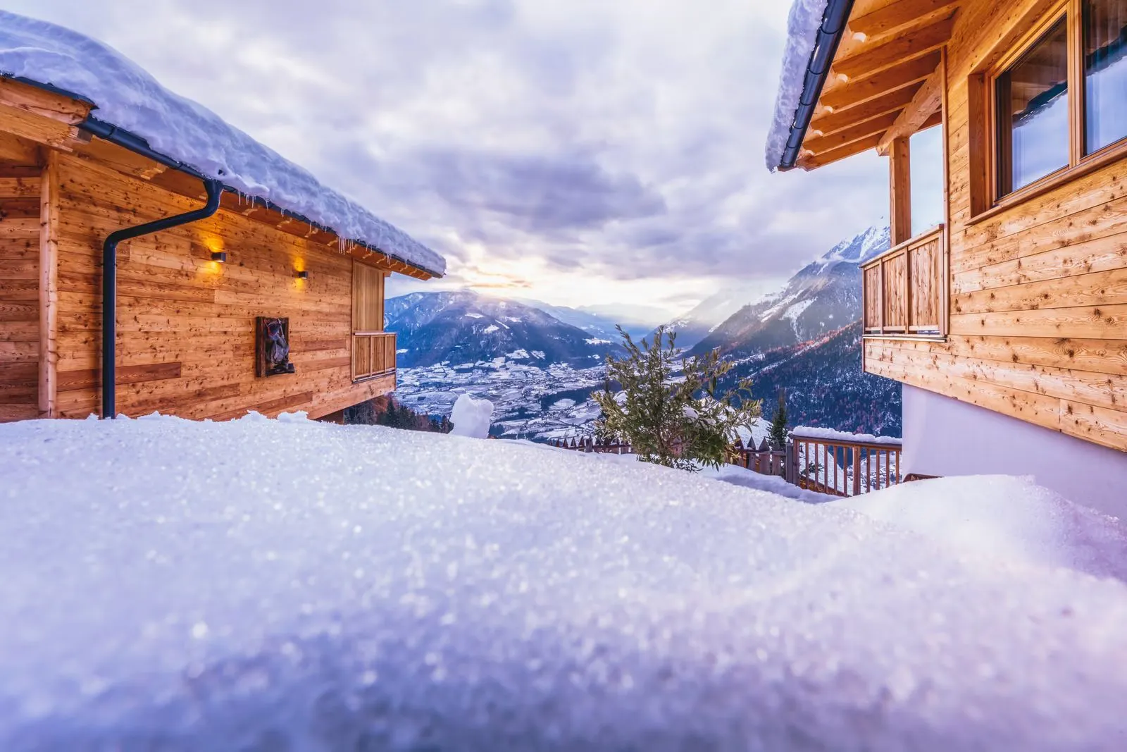 Die Chalets im letzten Abendlicht über dem verschneiten Tal