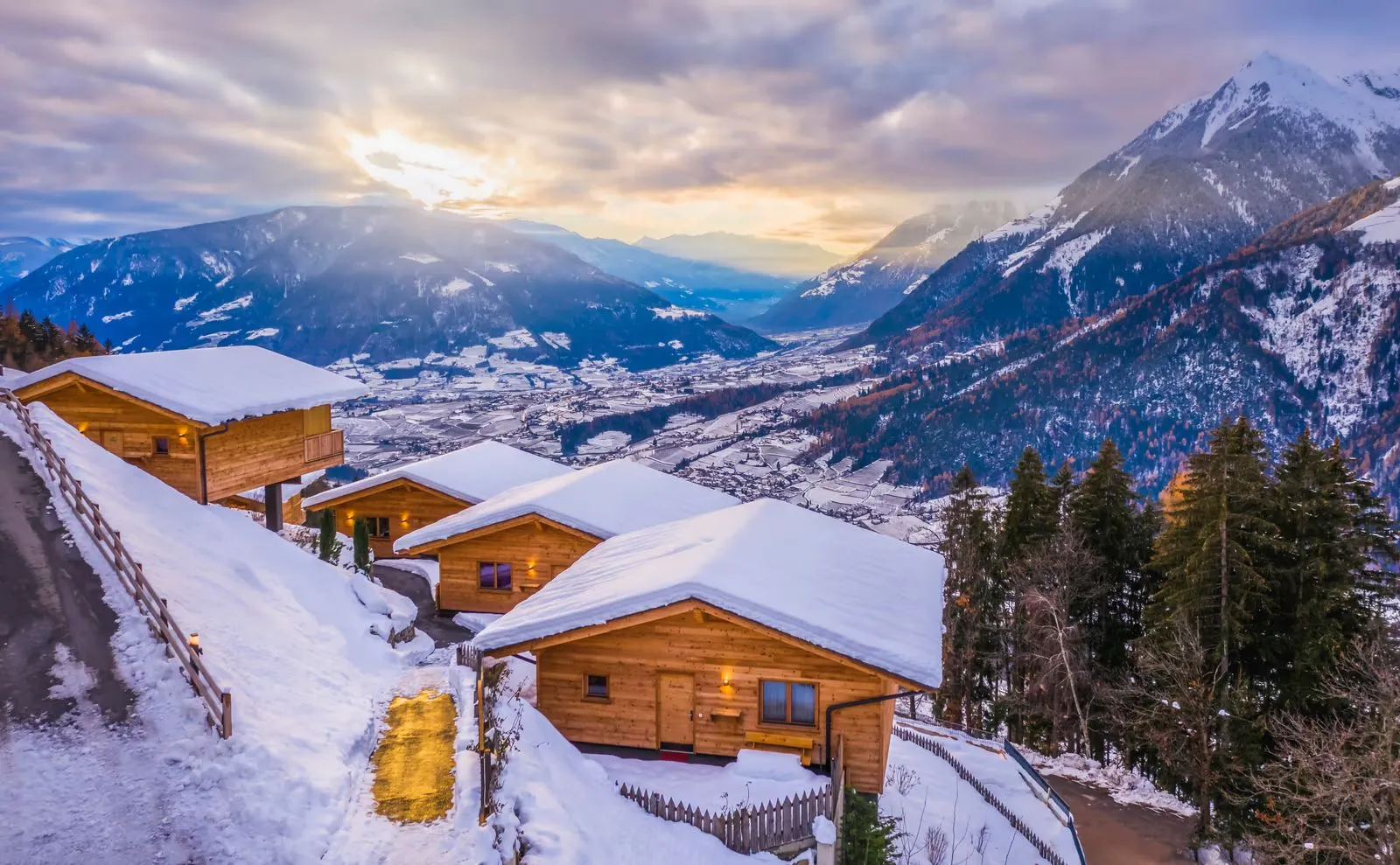 Das verschneite Chaletdorf Hasenegg von oben, dahinter die Berge