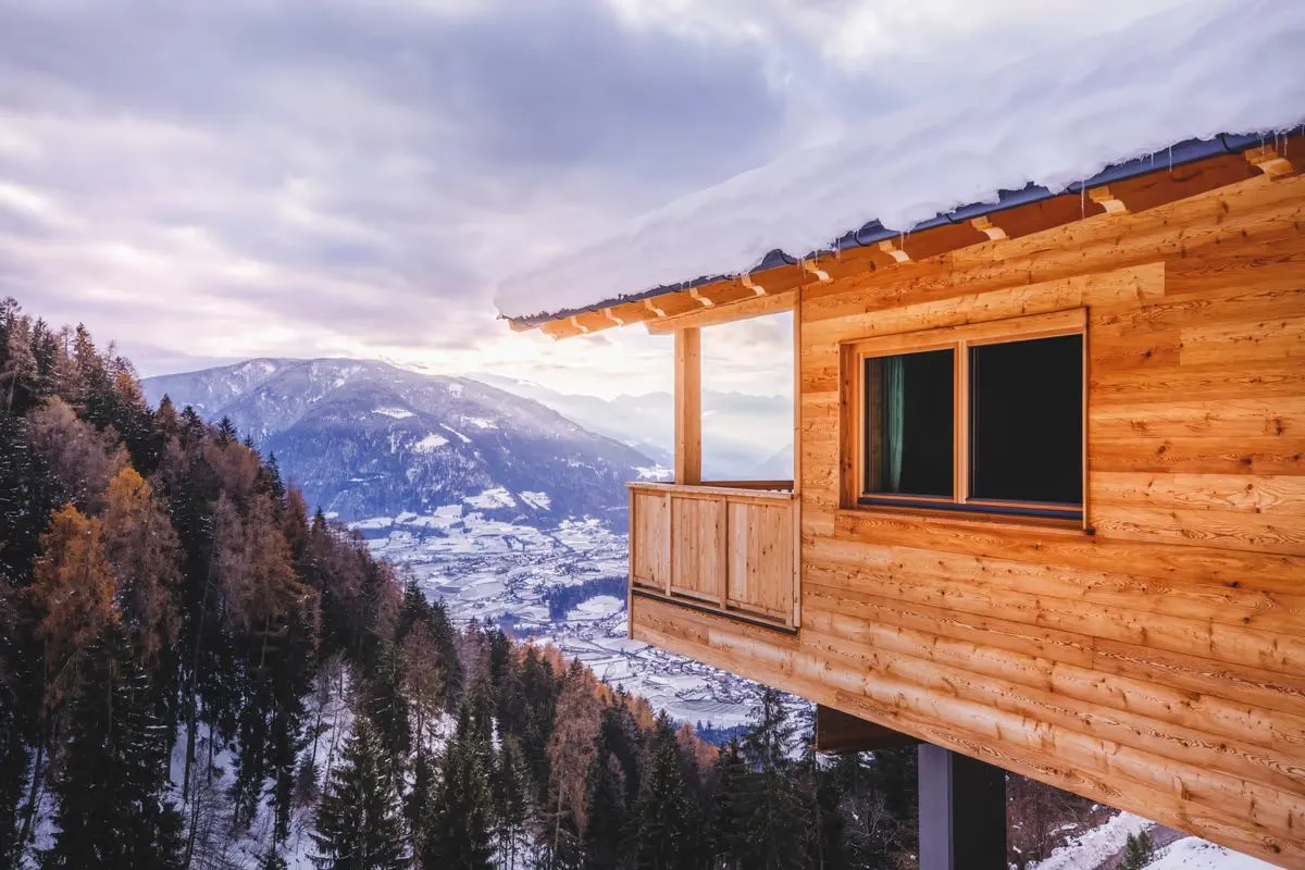 Blick vom verschneiten Chalet-Balkon über das Tal