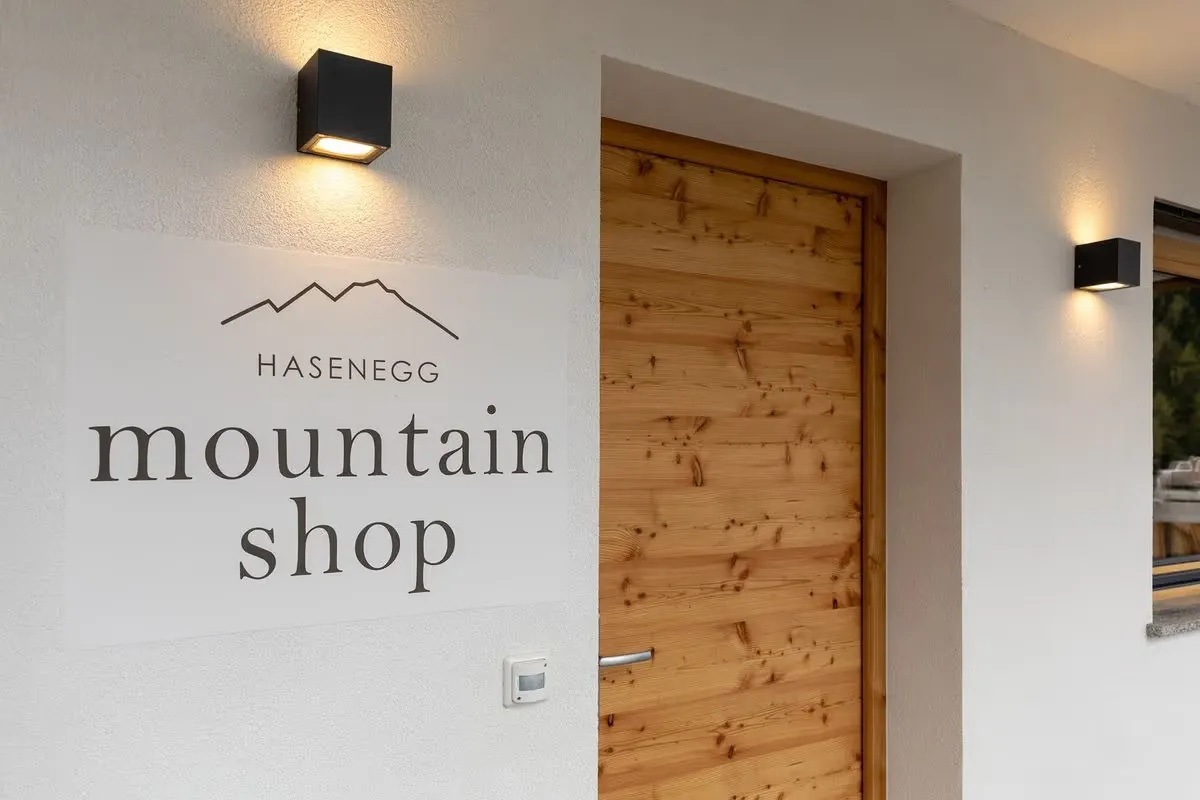 Eingang des Mountain Shop mit Holztür und dem Schild „Hasenegg mountain shop"