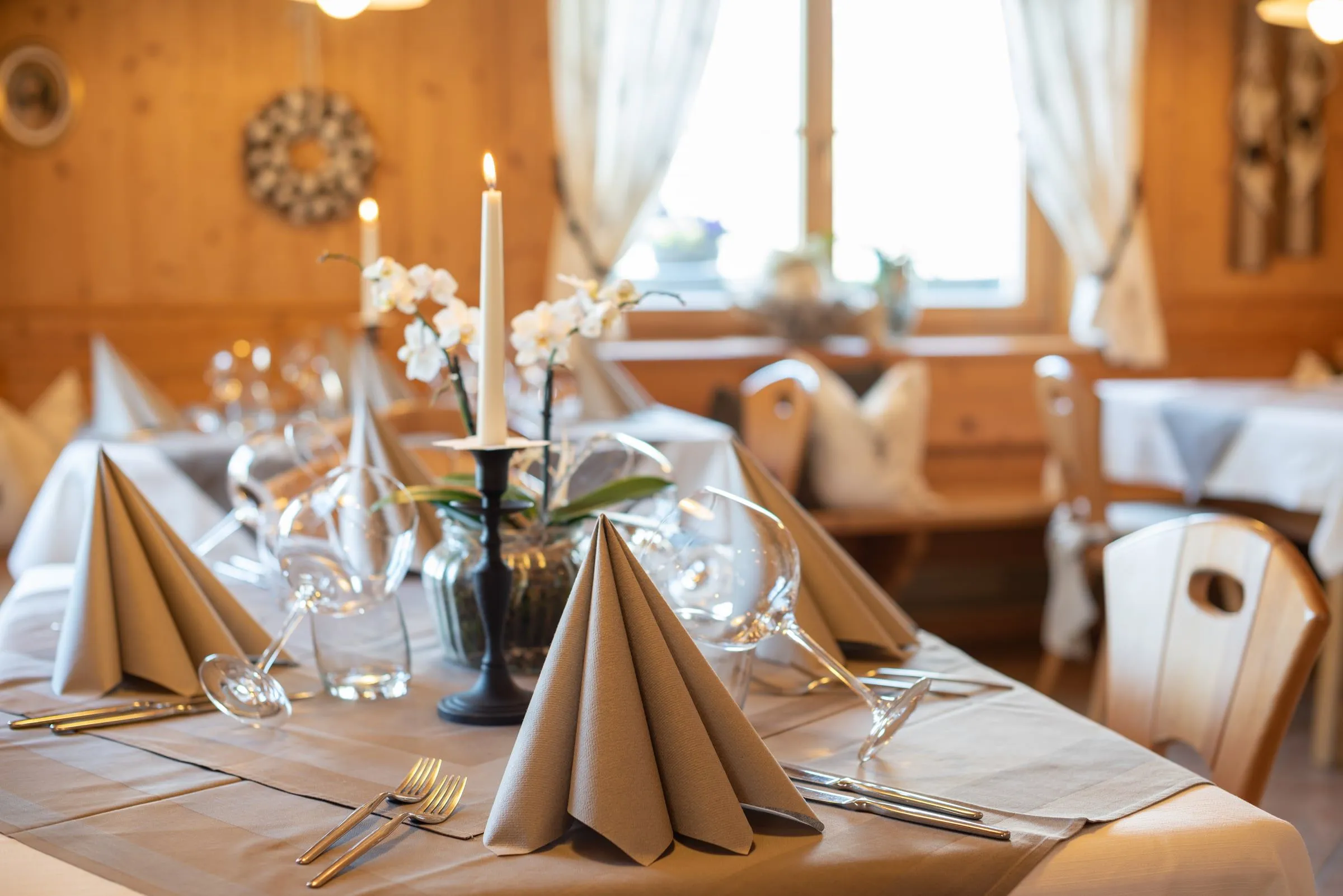Festlich gedeckter Tisch mit Kerzen, Gläsern und Servietten