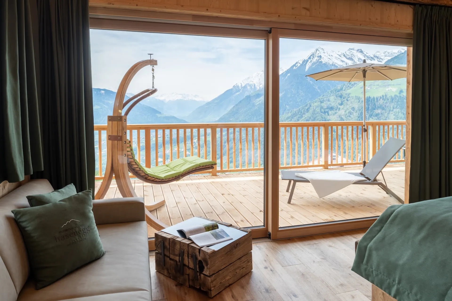 Monte Chalet – Wohnraum mit Terrasse und schneebedecktem Bergpanorama